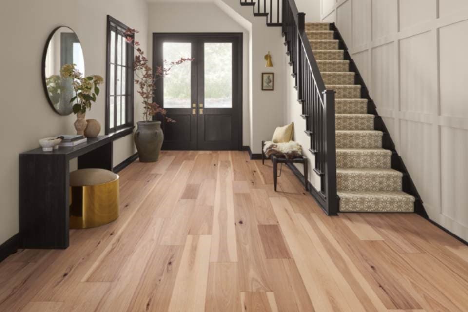 Character hickory hardwood flooring paired with a tailored geometric runner on a curved staircase