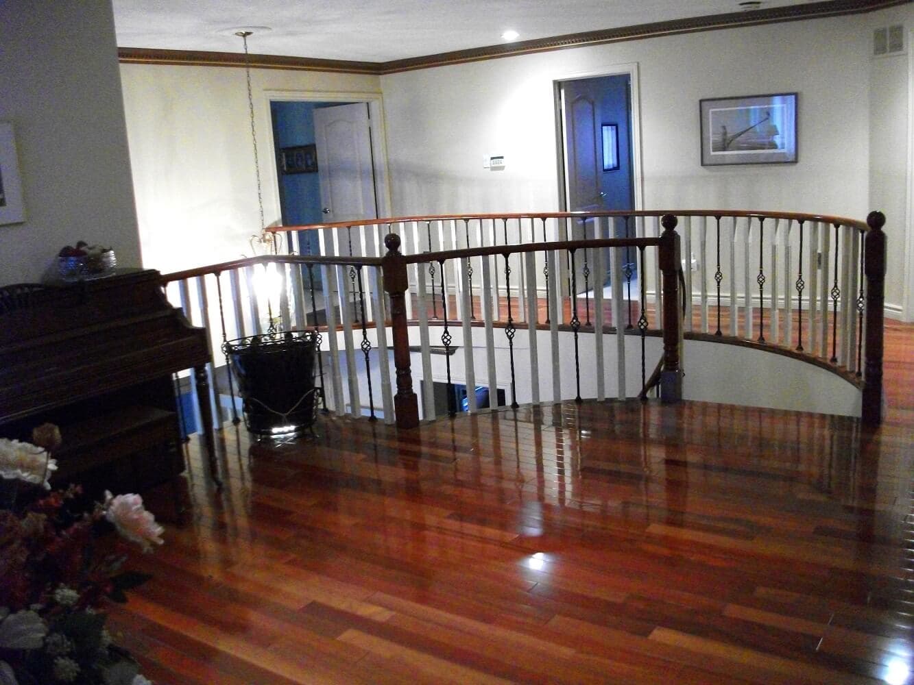 High-gloss Brazilian cherry Jatoba hardwood flooring along a curved second-floor landing