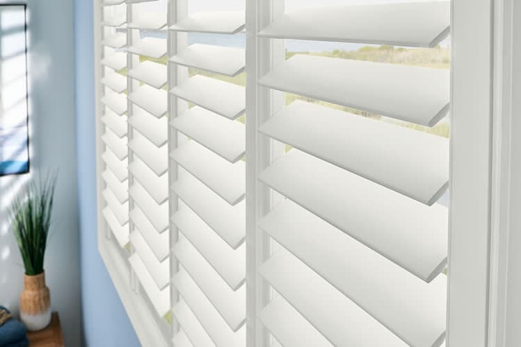 Architectural California Plantation Shutters - Window Coverings by Deluxe in Calgary Residence. Custom-crafted solid hardwood California shutters featuring wide 3.5-inch elliptical louvers and concealed tilt mechanisms for timeless architectural light control.