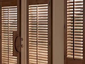Hardwood French Door Plantation Shutters - Window Coverings by Deluxe in Toronto Residence. Full-height wood plantation shutters custom-mortised with French door handle cutouts and independent upper/lower louver control for seamless patio access.