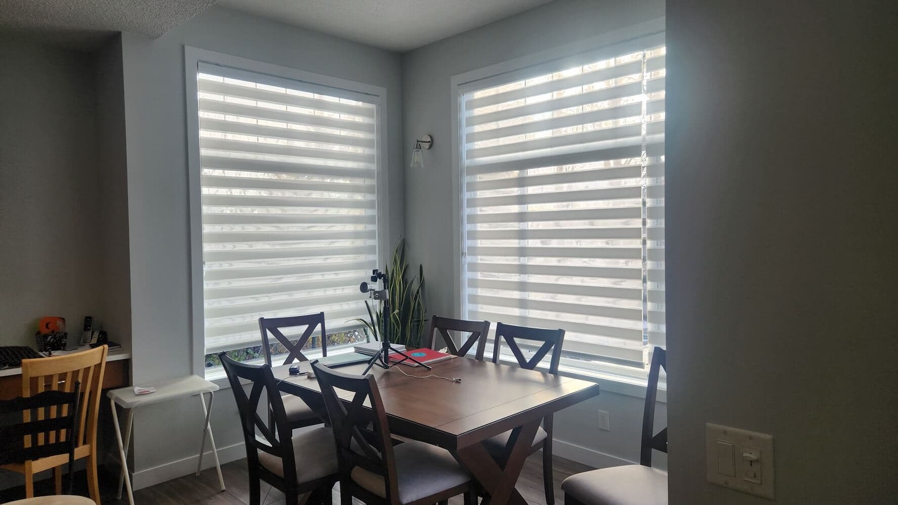 Modern Dining Room Dual-Band Zebra Blinds - Window Coverings by Deluxe in Calgary Residence. Precision dual-band sheer transitional zebra blinds in crisp white fabric, allowing alternating daytime light filtration and evening privacy in an open dining space.