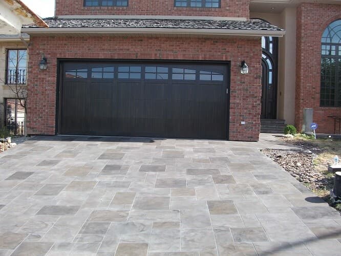 Custom Aris Stone driveway flooring in ashlar stone pattern in front of garage