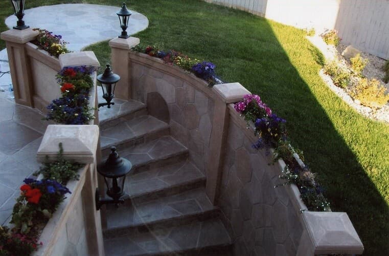 Aris Stone custom curved basement walkout staircase with retaining walls and integrated planters