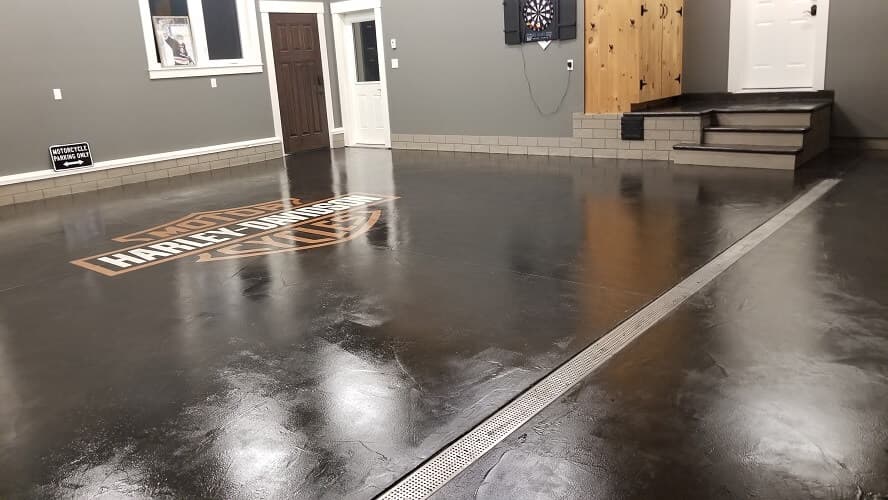 Custom Harley-Davidson Bar & Shield emblem inlaid garage floor with seamless stone finish