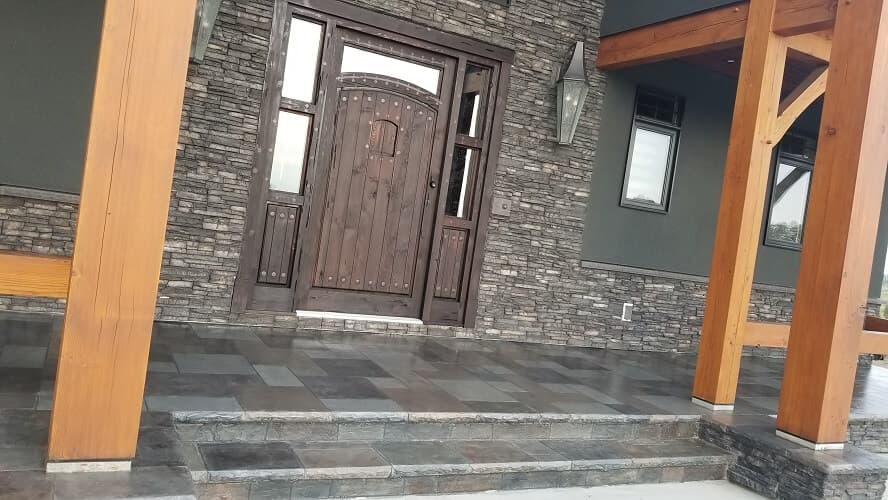 Timber-framed residential front porch featuring textured slate tiles and bullnose steps