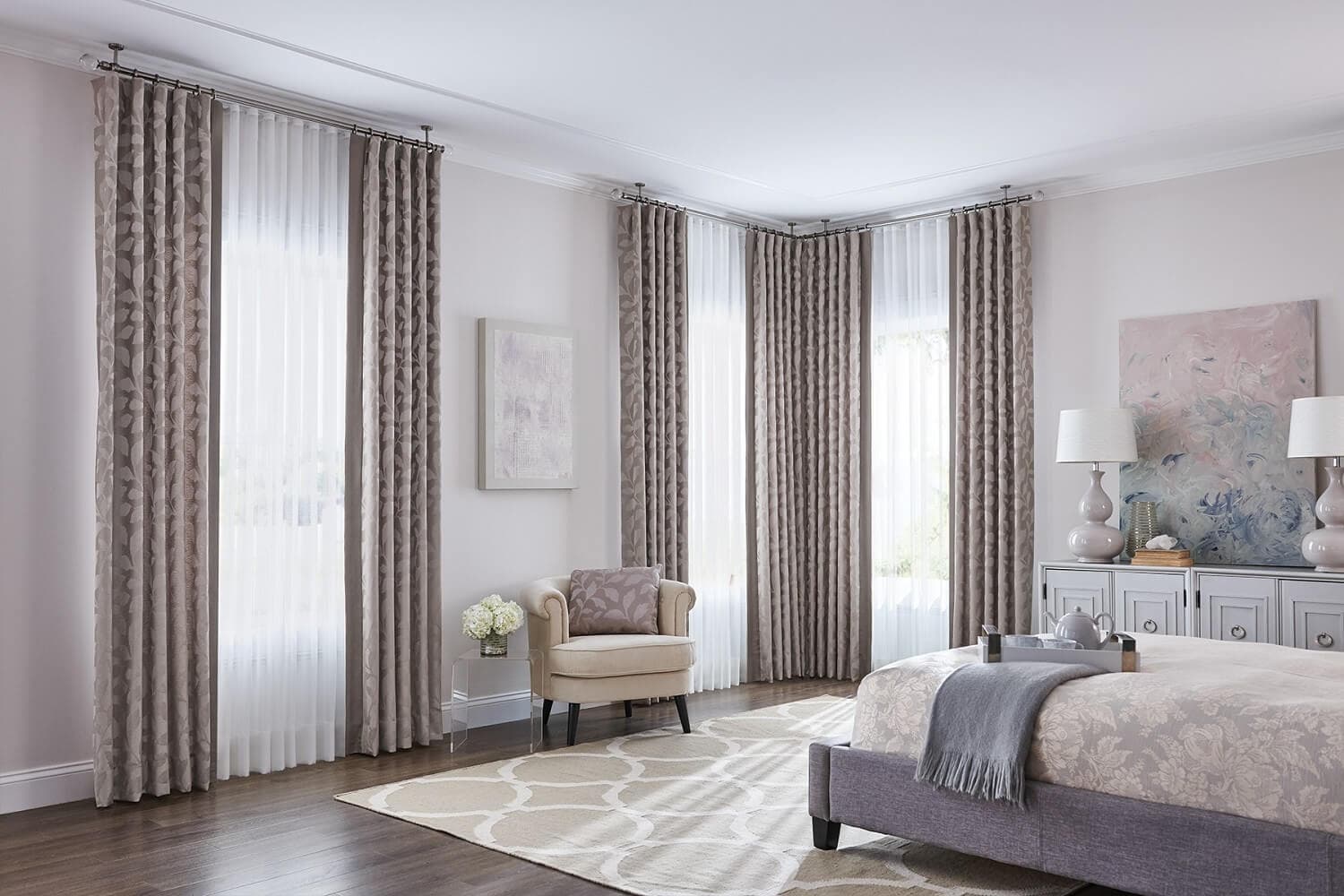 Floor-sweeping natural linen curtains hung on dark architectural metal drapery rods