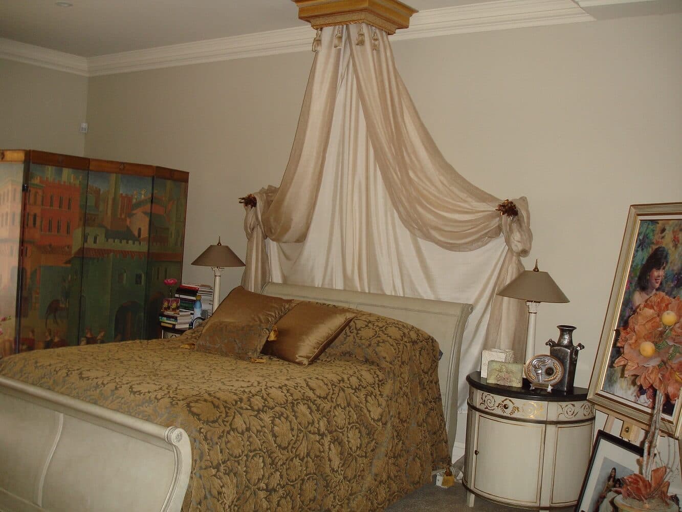 Crown canopy bed draped with flowing pleated sheer fabrics and decorative tiebacks