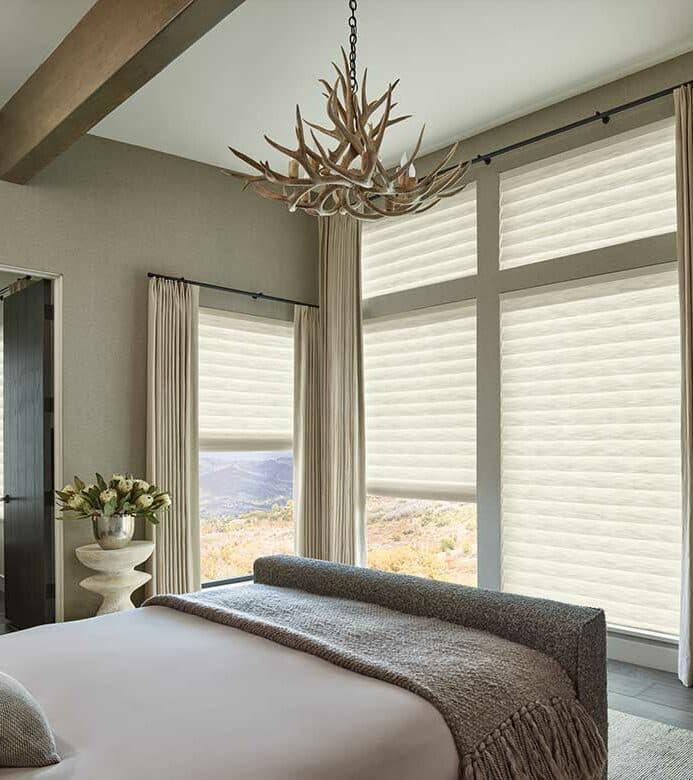 Insulating off-white cellular honeycomb shades inside bedroom window casing